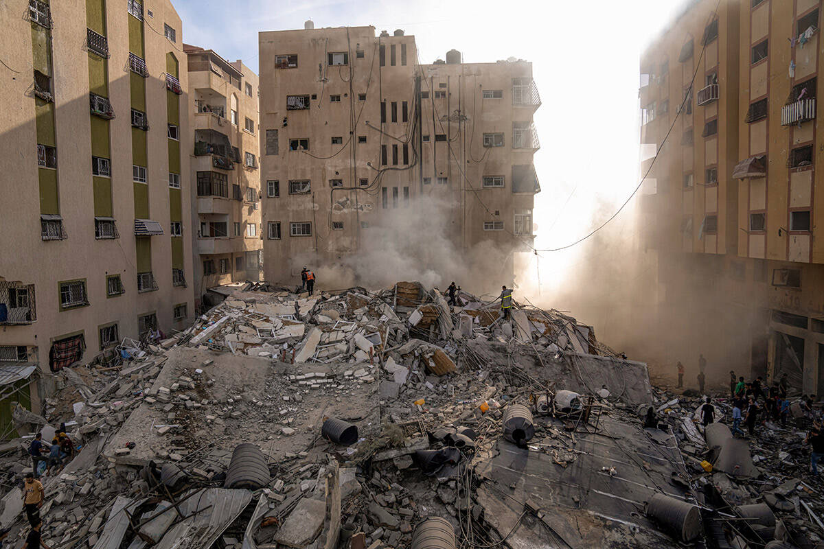 Palestinians inspect the rubble of a building after it was struck by an Israeli airstrike, in G ...