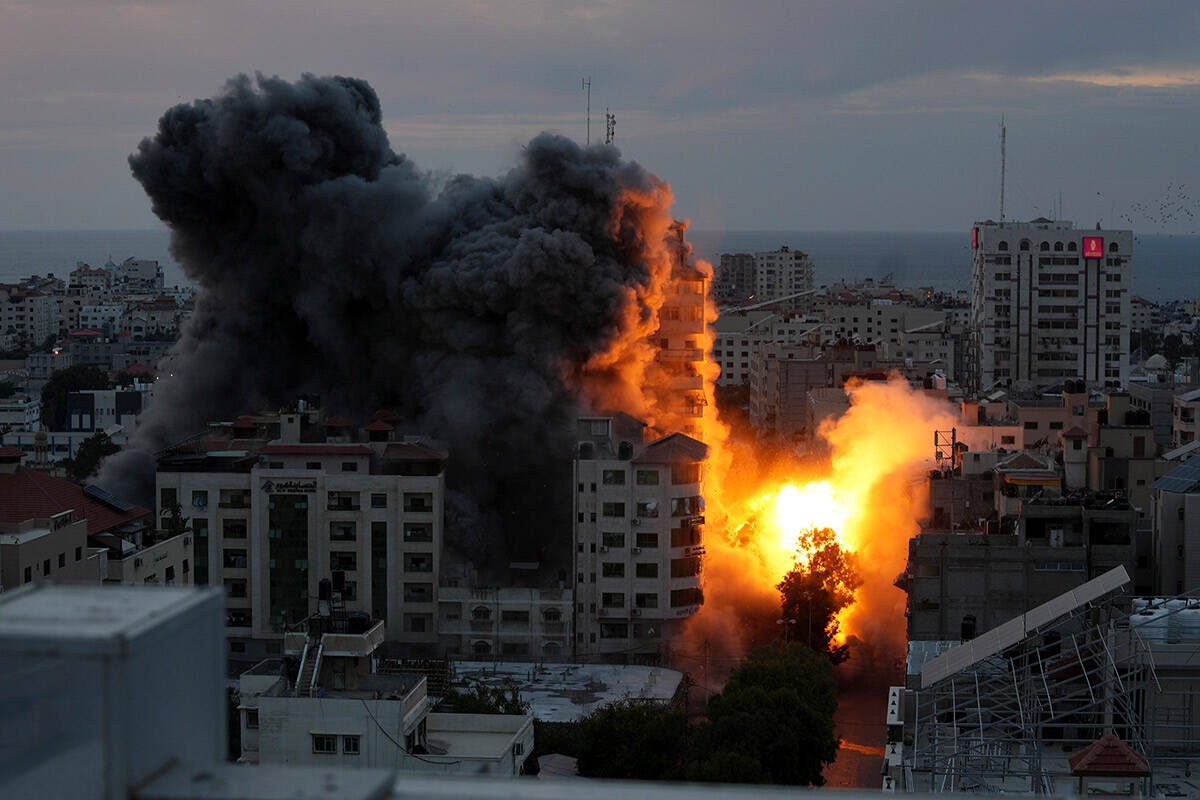 A ball of fire and smoke rise from an explosion on a Palestinian apartment tower following an I ...
