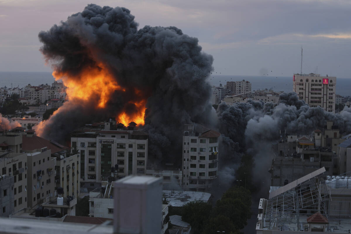 Fire and smoke rise from an explosion on a Palestinian apartment tower following an Israeli air ...