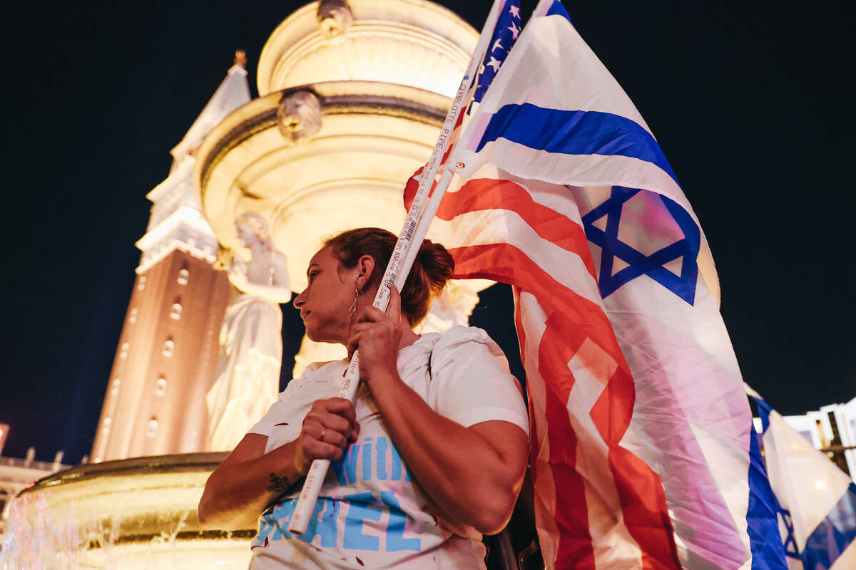 A person holds up an Israeli flag during a pro-Israel rally outside the Venetian on Sunday, Oct ...