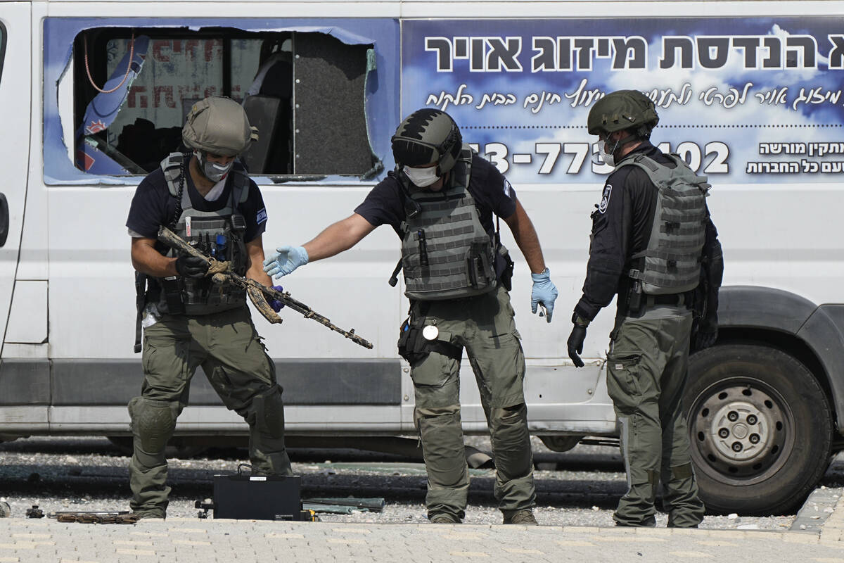 Israeli police retrieve weapons used by militants outside a police station that was overrun by ...