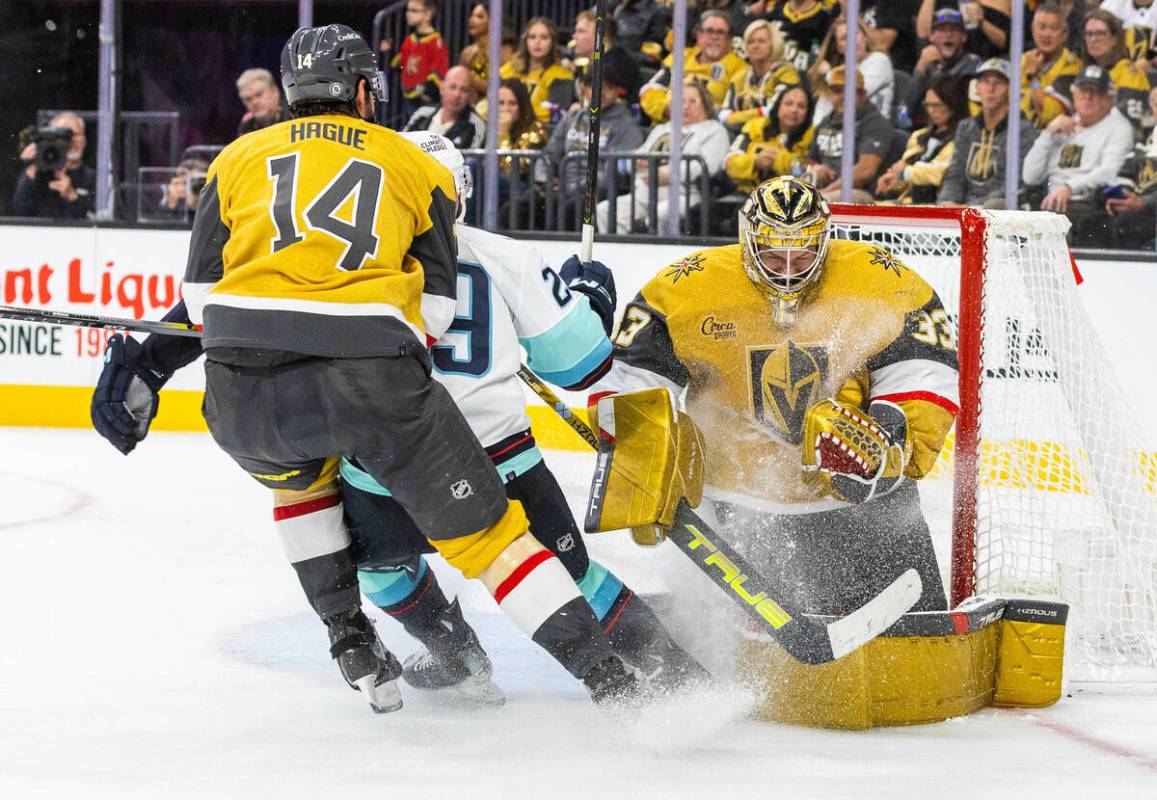 Golden Knights goaltender Adin Hill (33) holds onto a shot by Seattle Kraken defenseman Gustav ...