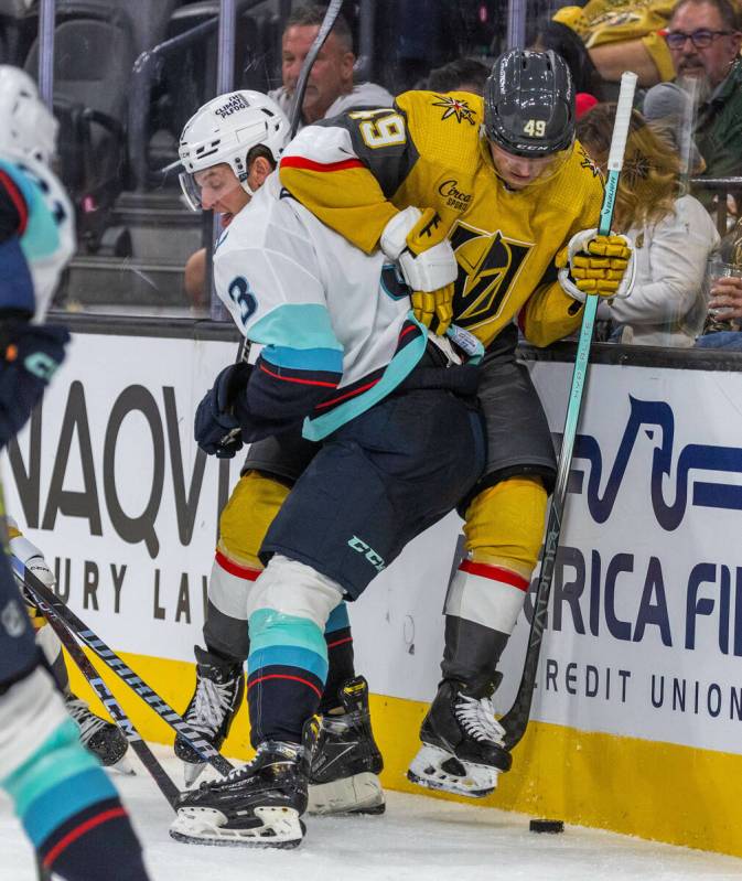 Seattle Kraken defenseman Will Borgen (3) drives Golden Knights center Ivan Barbashev (49) into ...