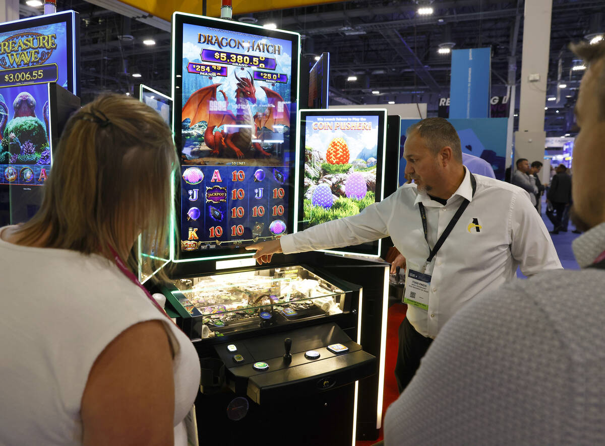 Todd Finco of Aries Technology demonstrates how Dragon Hatch game is played on CP3 cabinet at G ...
