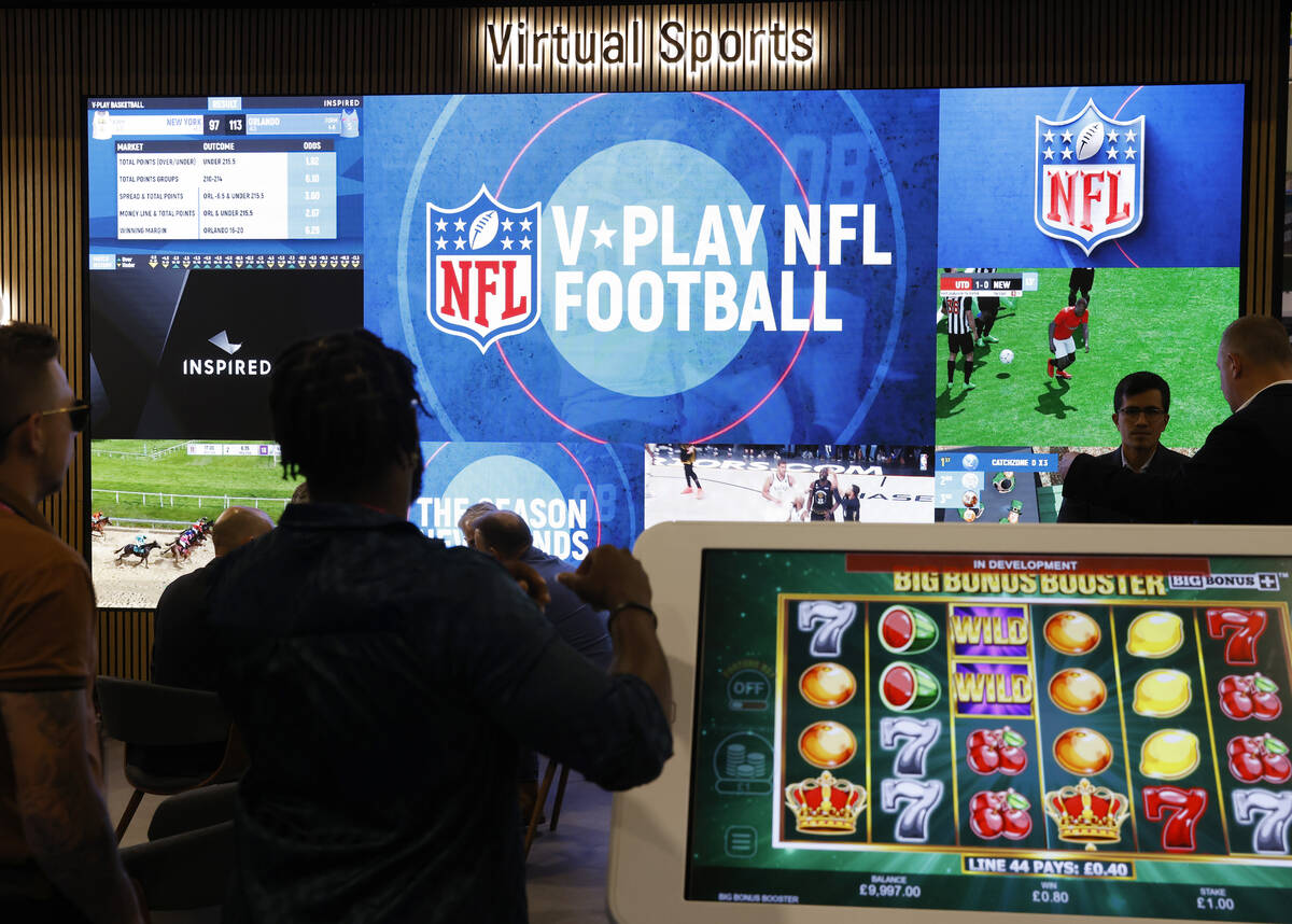 Conventioneers watch a display of Virtual Sports at Inspired booth at G2E Las Vegas at Sands Ex ...
