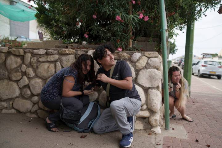 Israelis take cover from the incoming rocket fire from the Gaza Strip in Ashkelon, Israel, on W ...