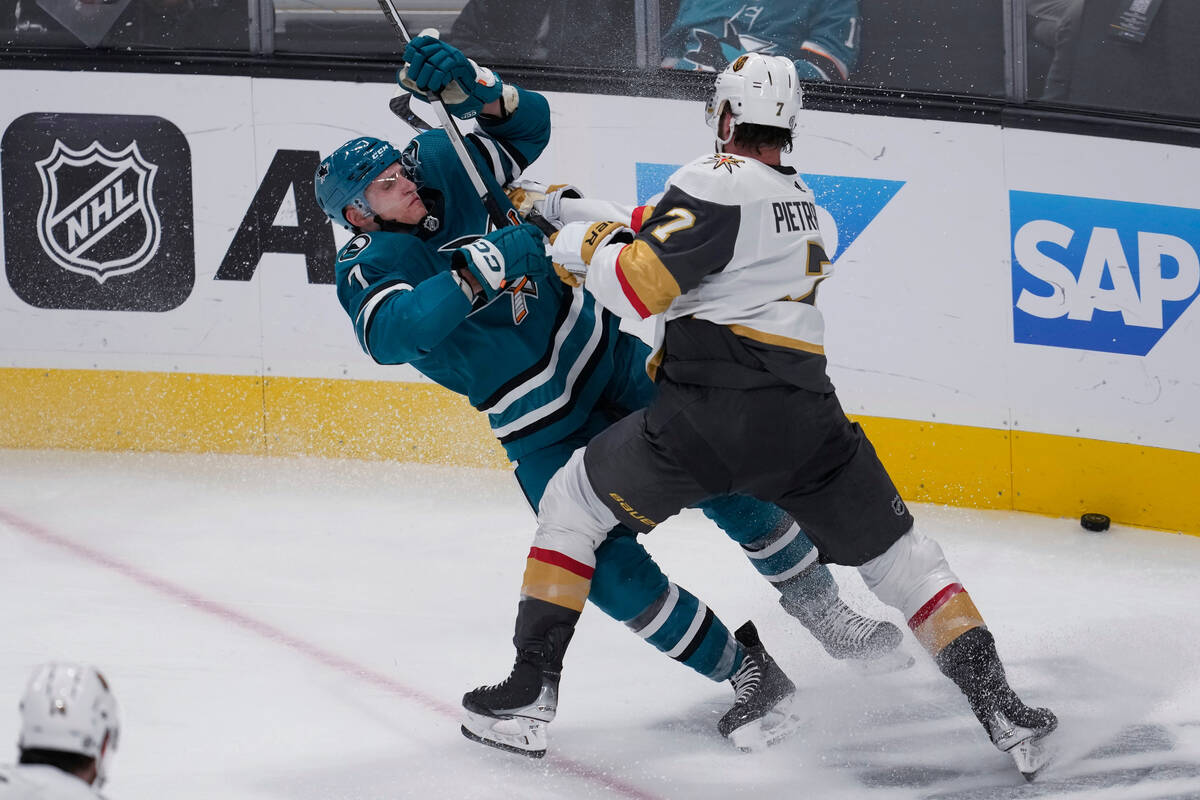 San Jose Sharks center Nico Sturm, left, is hit by Vegas Golden Knights defenseman Alex Pietran ...