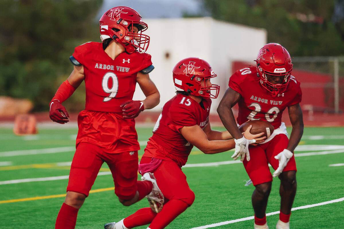 Arbor View quarterback Sean Griese (15) hands the ball off to Arbor view running back Kamareion ...