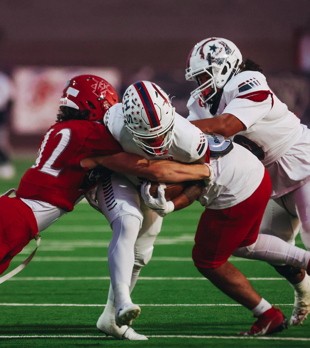 Liberty running back Isaiah Lauofo (3) runs the ball through Arbor View defenders during a game ...