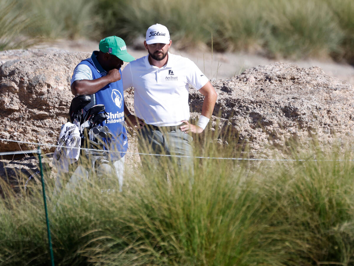 Hayden Buckley, right, discuss with his caddie after he lost the ball near the 16th green durin ...