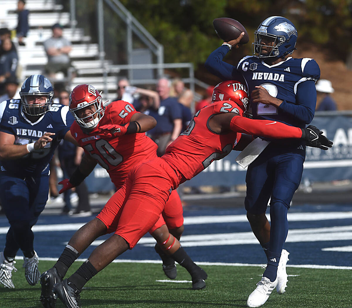 Nevada’s Brendon Lewis gets hit by UNLV’s Ose Egbase as he makes a throw at Mackay Stadium ...