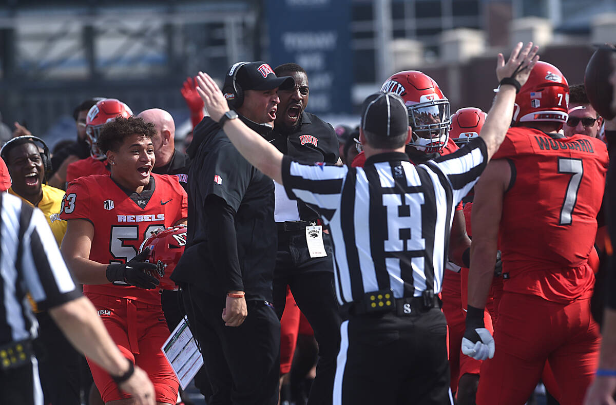 The UNLV bench celebrates an interception by Jackson Woodard while taking on Nevada at Mackay S ...