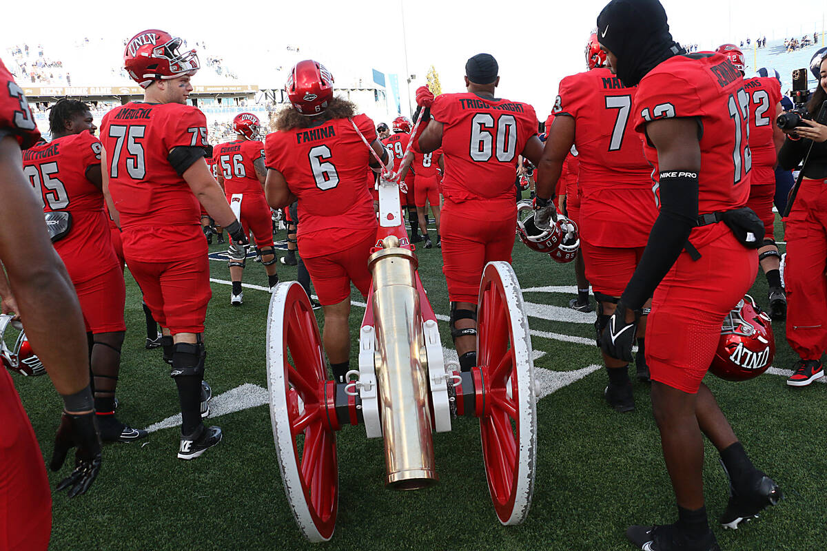 UNLV players celebrate their victory over Nevada by claiming the Fremont Cannon at Mackay Stadi ...