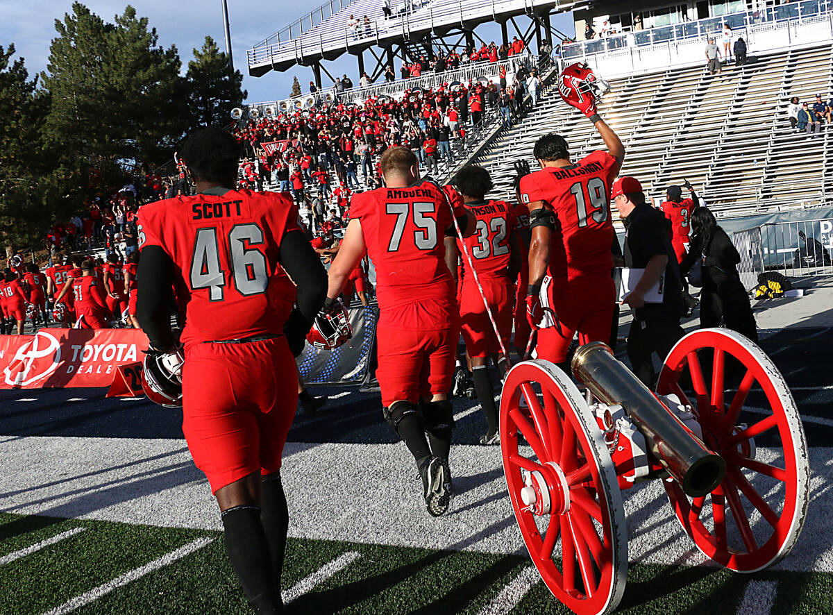 UNLV players celebrate their victory over Nevada by claiming the Fremont Cannon at Mackay Stadi ...