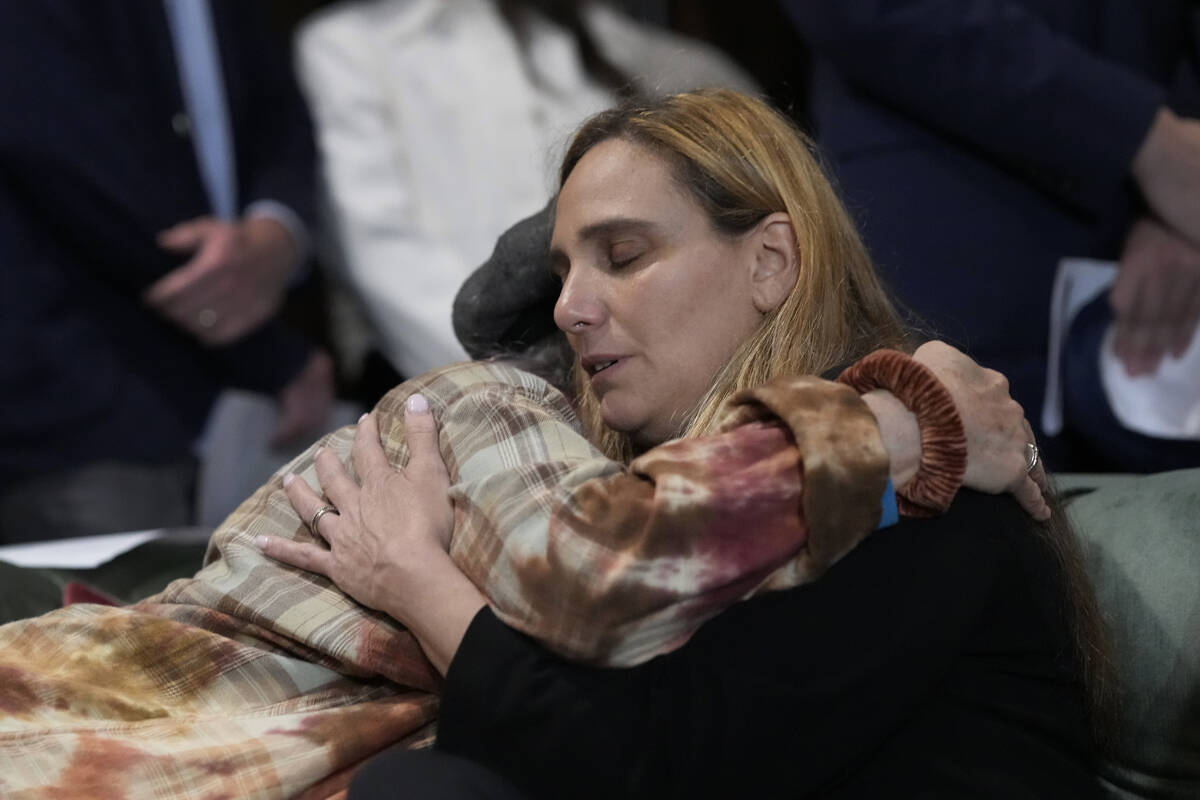 Sigal Zamir, right, is comforted at a prayer vigil for Judith Raanan and her daughter Natalie o ...
