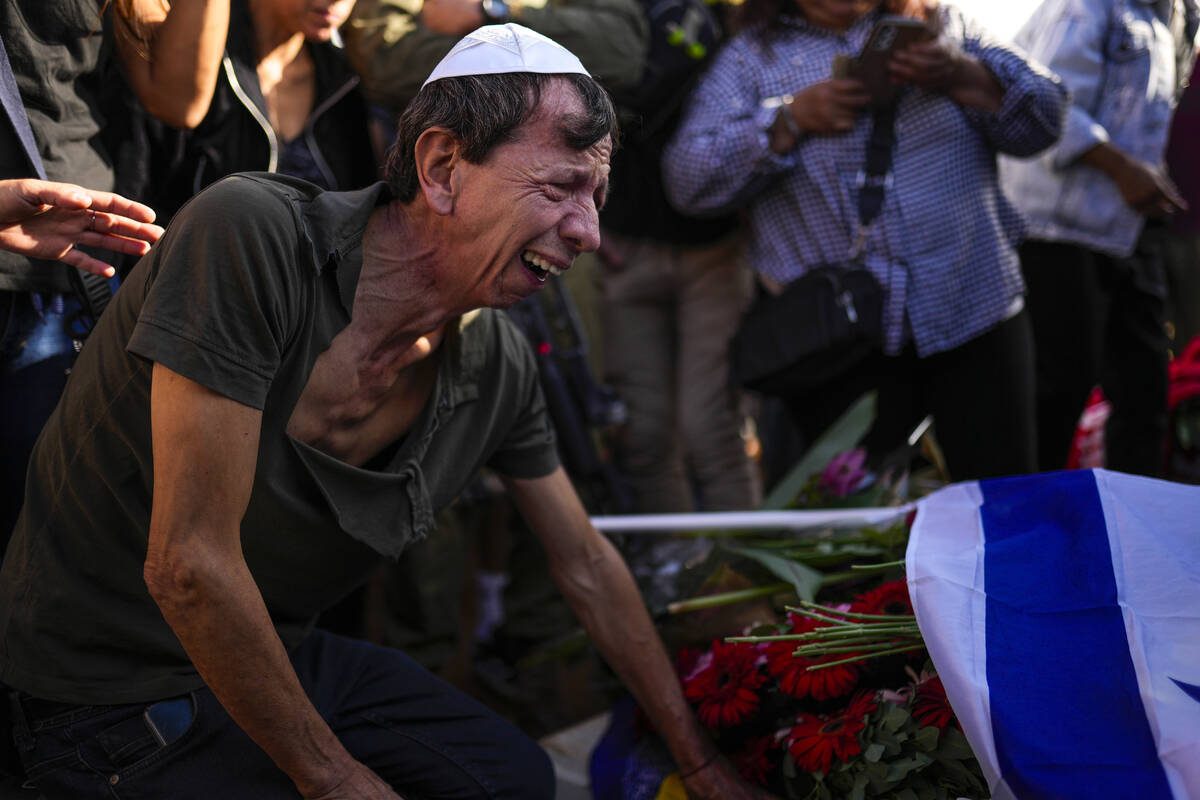 A man mourns during the funeral of Antonio Macias at Pardes Haim cemetery in Kfar Saba, near Te ...