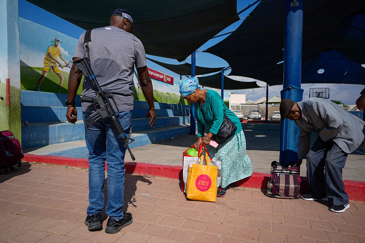 Israelis carry their belongings as they evacuate from the southern Israeli town of Sderot, Sund ...