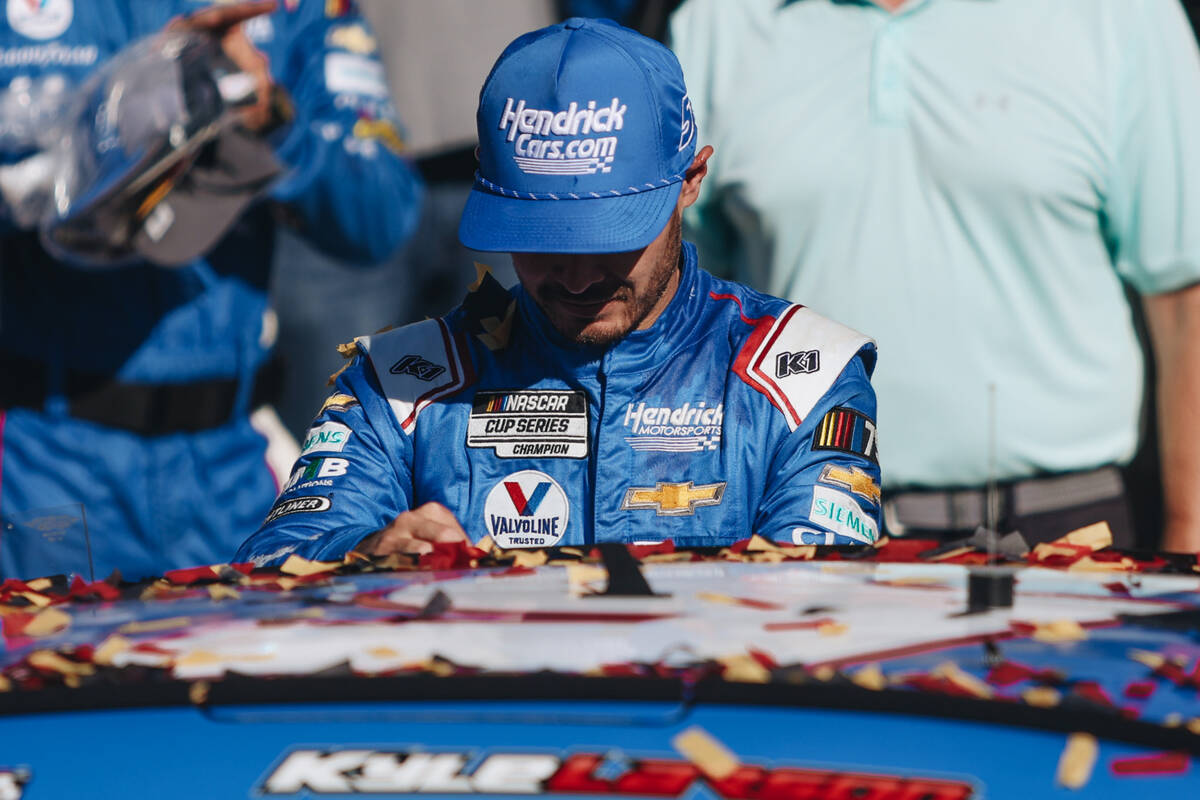 Kyle Larson places a sticker on his car to commemorate him winning the South Point 400 at the ...