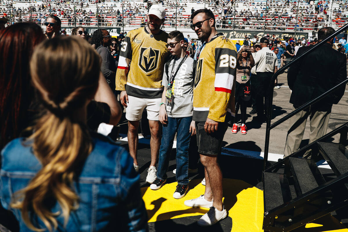 Golden Knights teammates Adin Hill, left, and William Carrier, right, pose with a fan during th ...