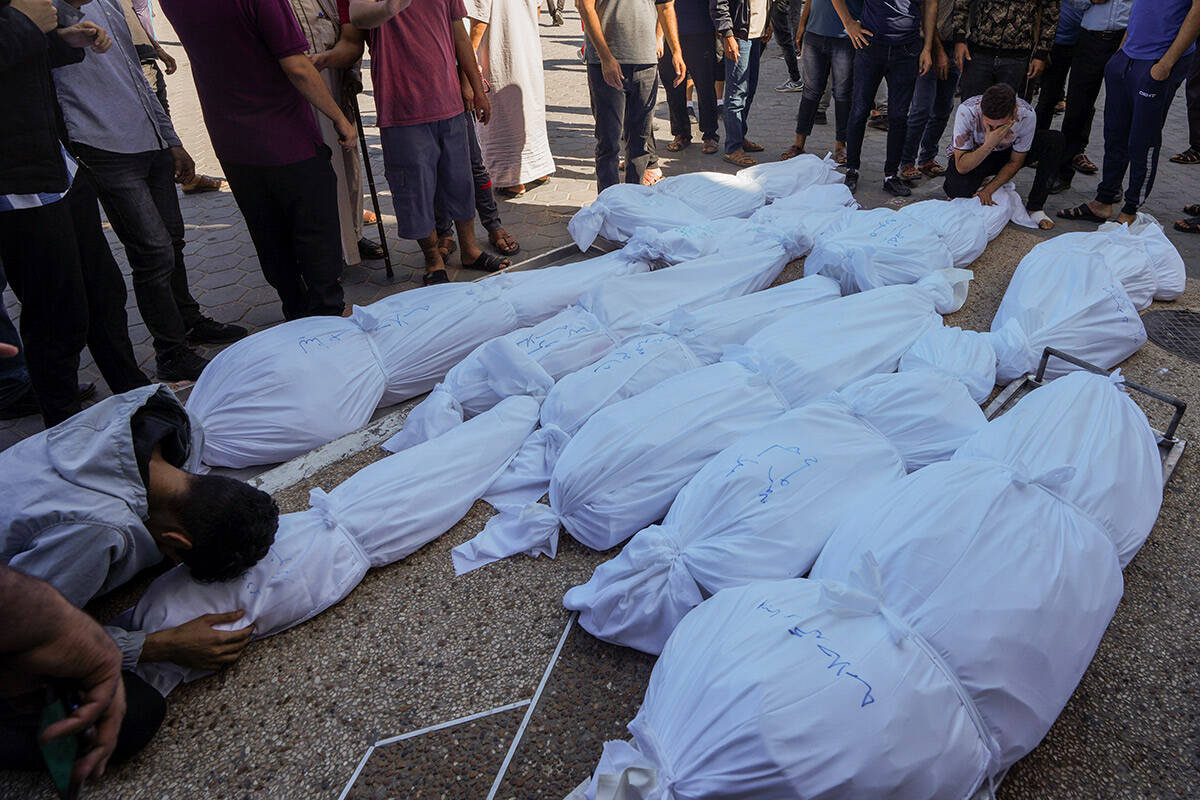 Outside al-Aqsa hospital in Deir el-Balah, central Gaza Strip, Palestinians mourn over the bodi ...