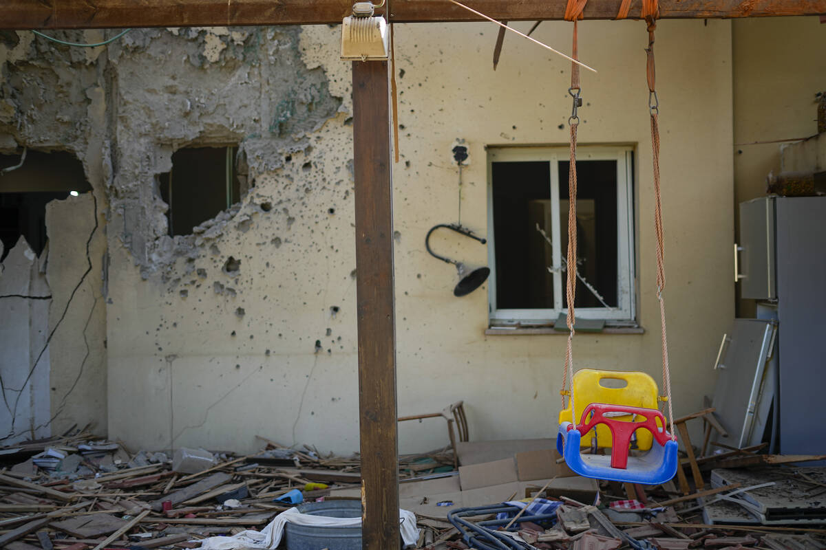 A children's swing hangs in a house damaged by Hamas militants is seen in Kibbutz Be'eri, Israe ...