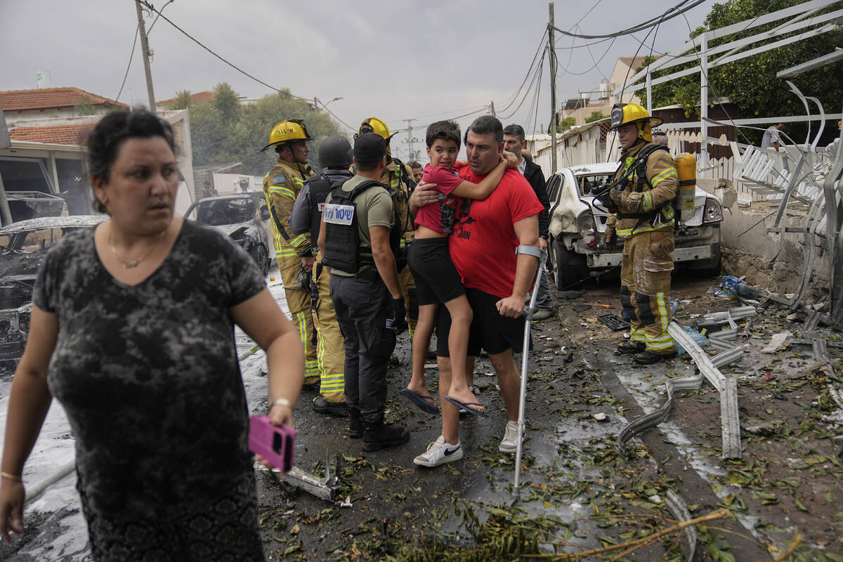 Israelis evacuate a site struck by a rocket fired from the Gaza Strip, in Ashkelon, southern Is ...