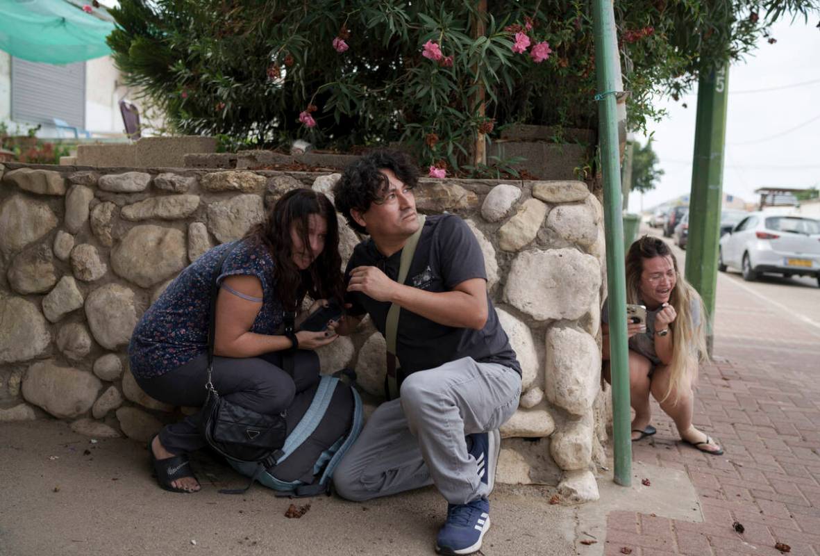 Israelis take cover from the incoming rocket fire from the Gaza Strip in Ashkelon, southern Isr ...