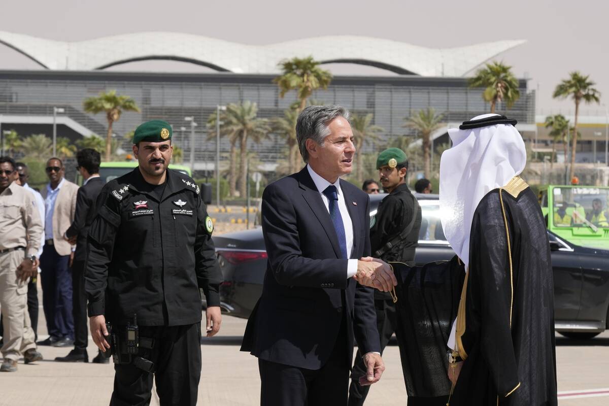 U.S. Secretary of State Antony Blinken shakes hands with a Saudi official before boarding a pla ...