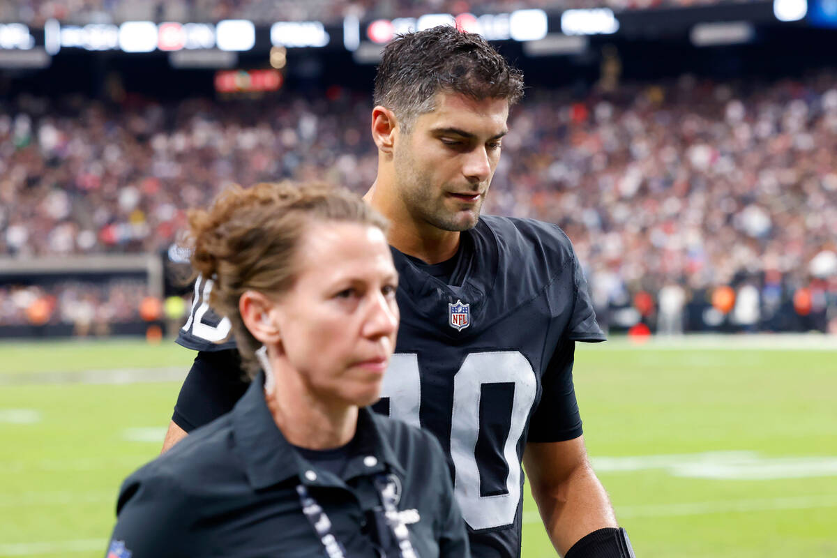 Raiders quarterback Jimmy Garoppolo (10) is escorted out of the field during an NFL football ga ...