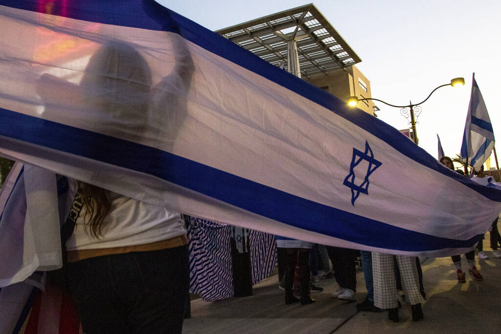 Pro-Israel protesters hang up a banner on Tuesday, Oct. 17, 2023, in Las Vegas (AP Photo/Ty ONeil)
