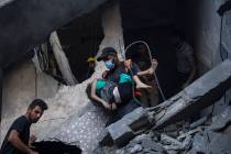 Palestinians evacuate wounded from a building destroyed in Israeli bombardment in Khan Younis, ...