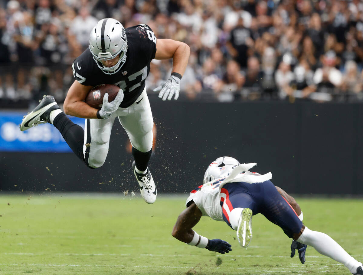 Raiders tight end Michael Mayer (87) leaps over New England Patriots cornerback Jalen Mills (2) ...