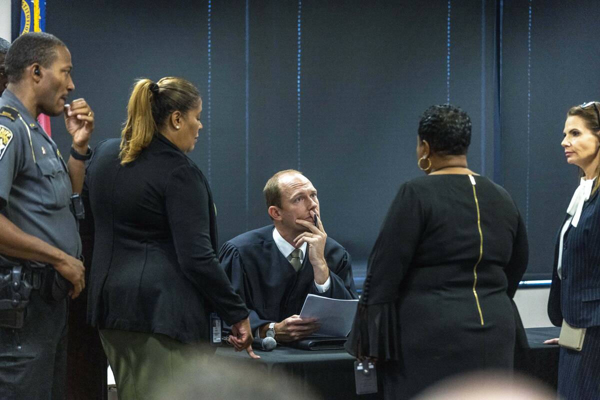 Fulton Superior Court Judge Scott McAfee, center, receives information during jury selection fo ...