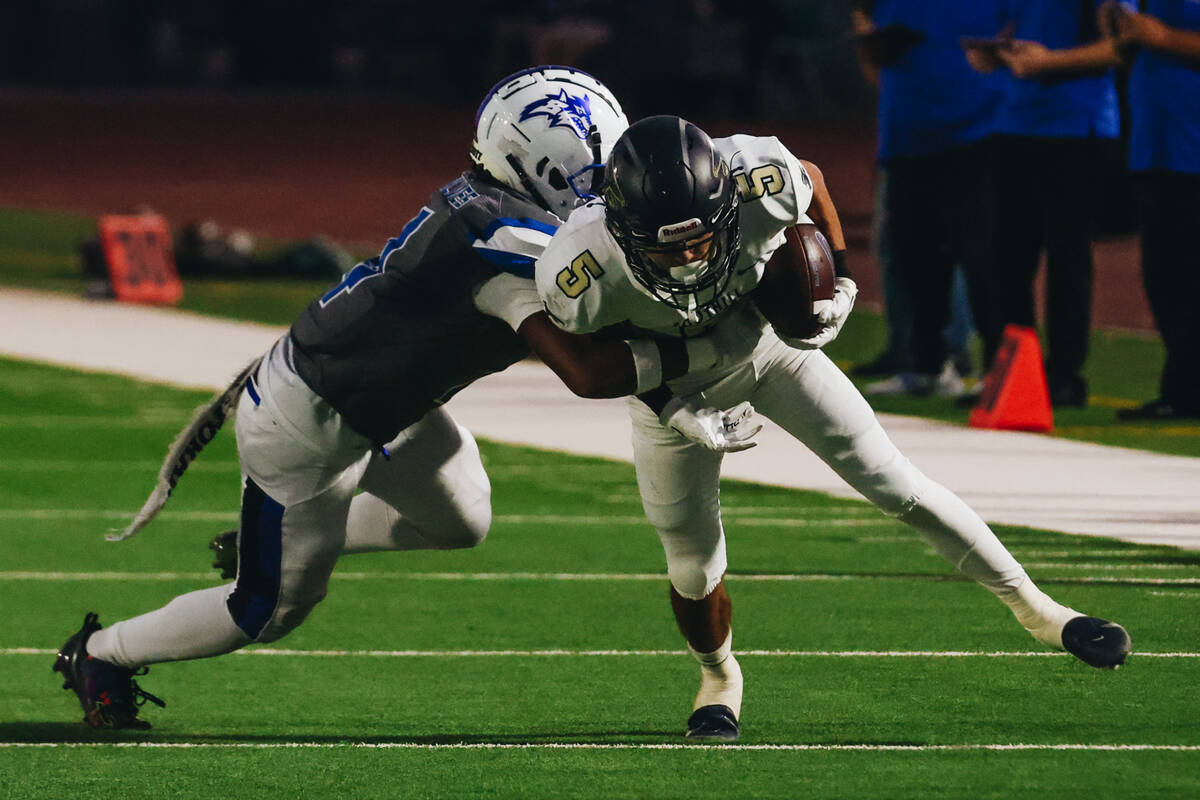 Basic cornerback Chris Smith (4) grabs onto Foothill wide receiver Chase Kennedy (5) as he carr ...