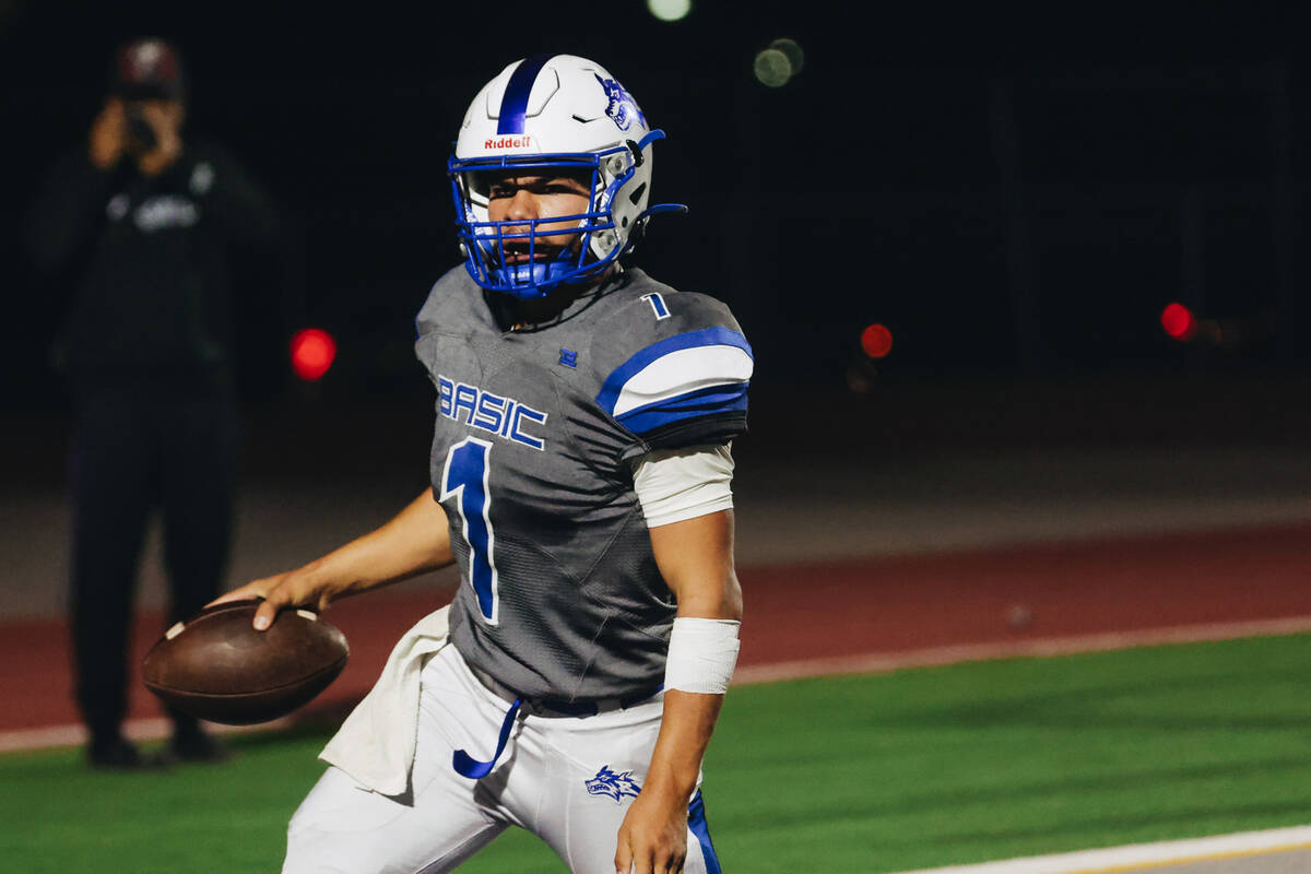 Basic quarterback Anthony Vega (1) runs the ball into the end zone for a touchdown during a gam ...