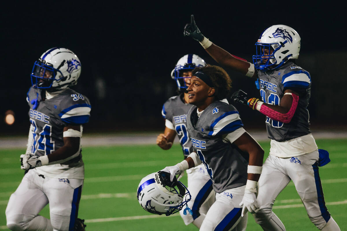 Basic players and coaching staff celebrate their win over Foothill following a game at Basic Ac ...