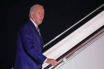 President Joe Biden answers a questions as he boards Air Force One at Andrews Air Force Base, M ...