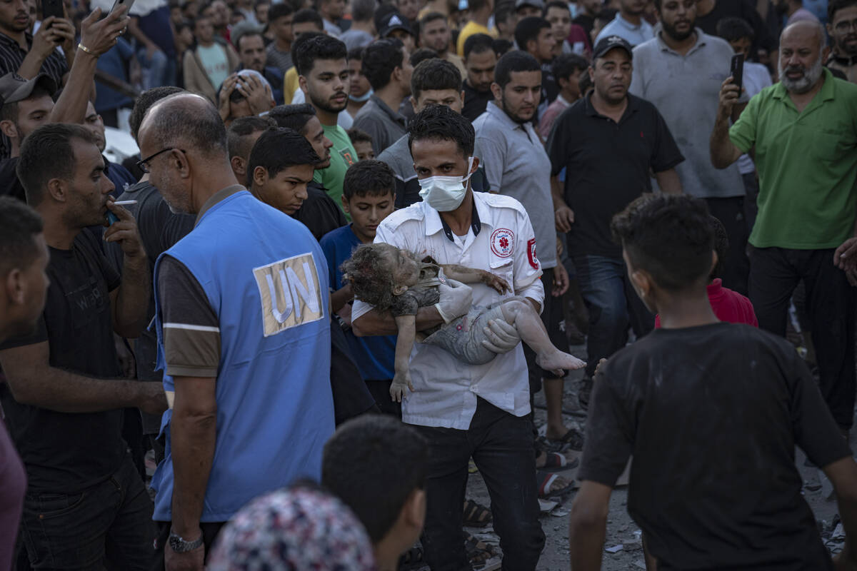 A child is carried from the rubble of a building after an airstrike in Khan Younis, Gaza Strip, ...