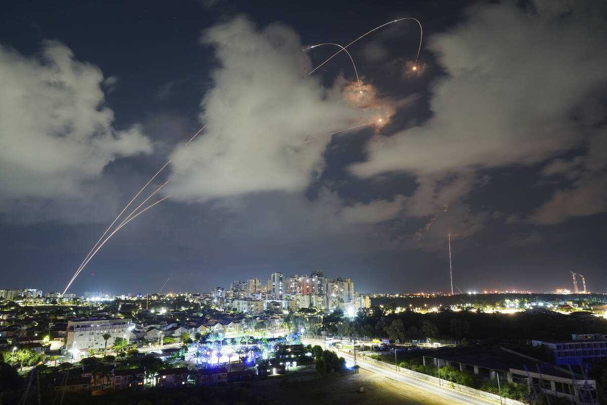 File - Rockets from the Israeli Iron Dome air defense system maneuver to intercept a rocket fir ...