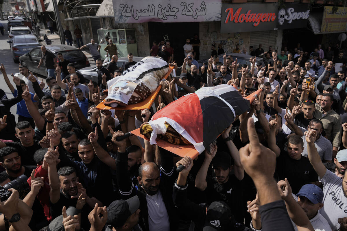 Palestinians carry the bodies of Muhammed Hussein, draped in the Palestinian flag and Muhammad ...