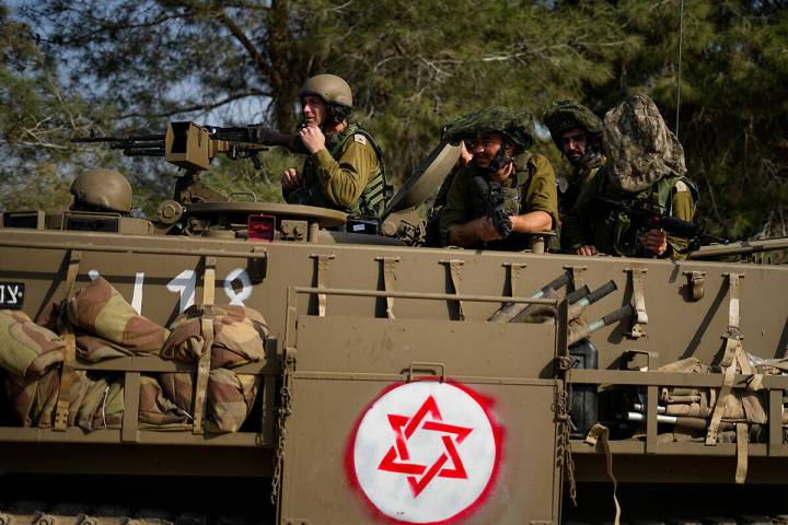 Israeli soldiers drive an armoured personnel carrier (APC) near the border with the Gaza Strip, ...