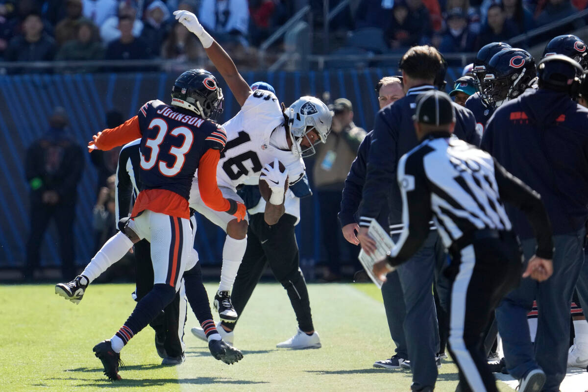 Las Vegas Raiders wide receiver Jakobi Meyers (16) is pushed out of bounds by Chicago Bears cor ...