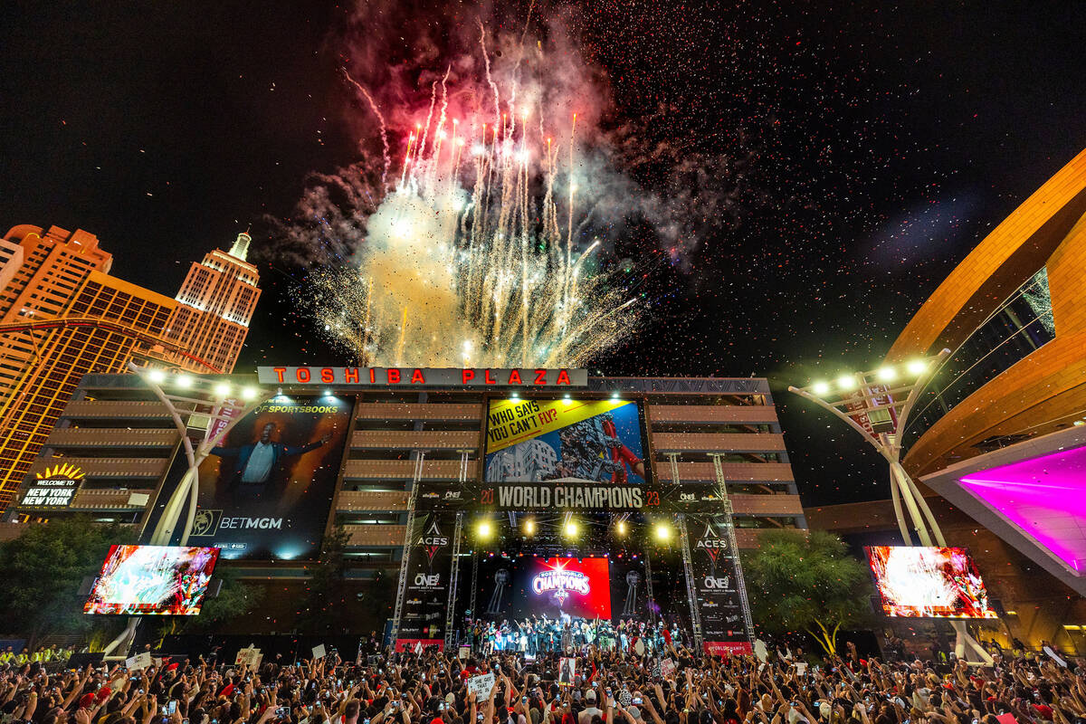 Aces players party on stage as fireworks erupt overhead during their championship celebration ...