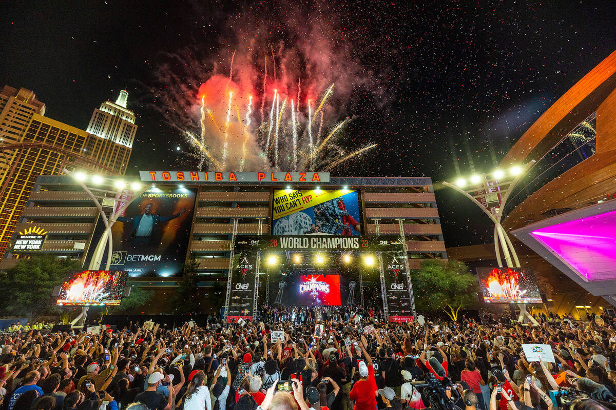 Aces players party on stage as fireworks erupt overhead during their championship celebration ...