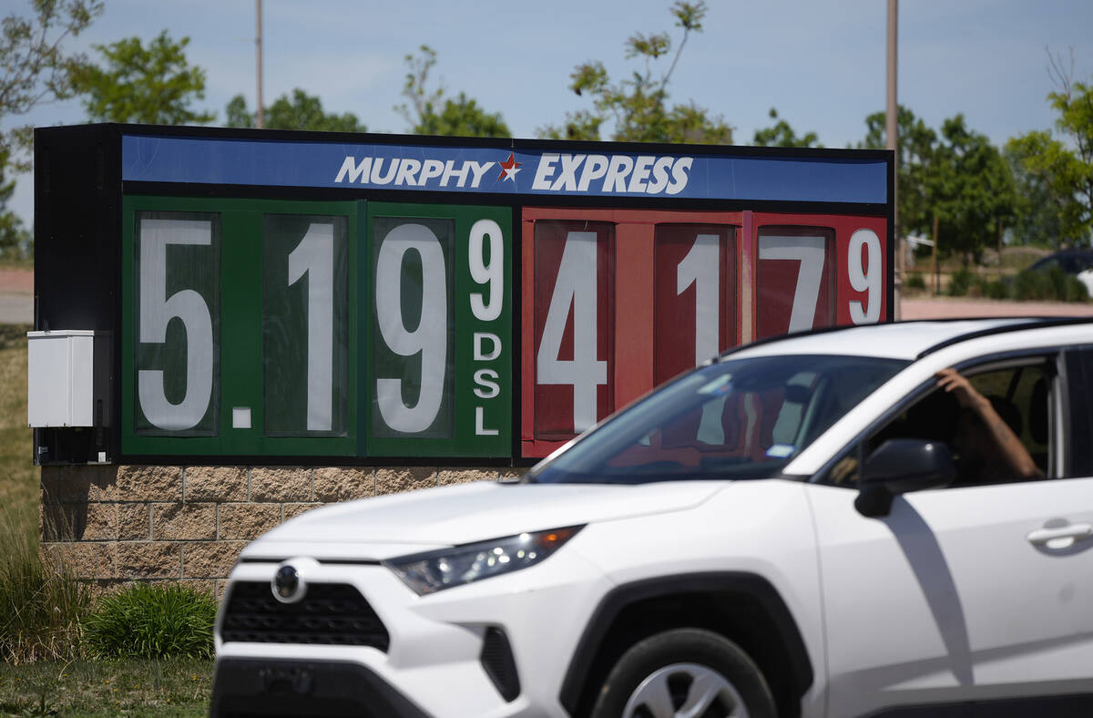 Gasoline prices are displayed outside a convenience store as a motorist drives by Thursday, May ...