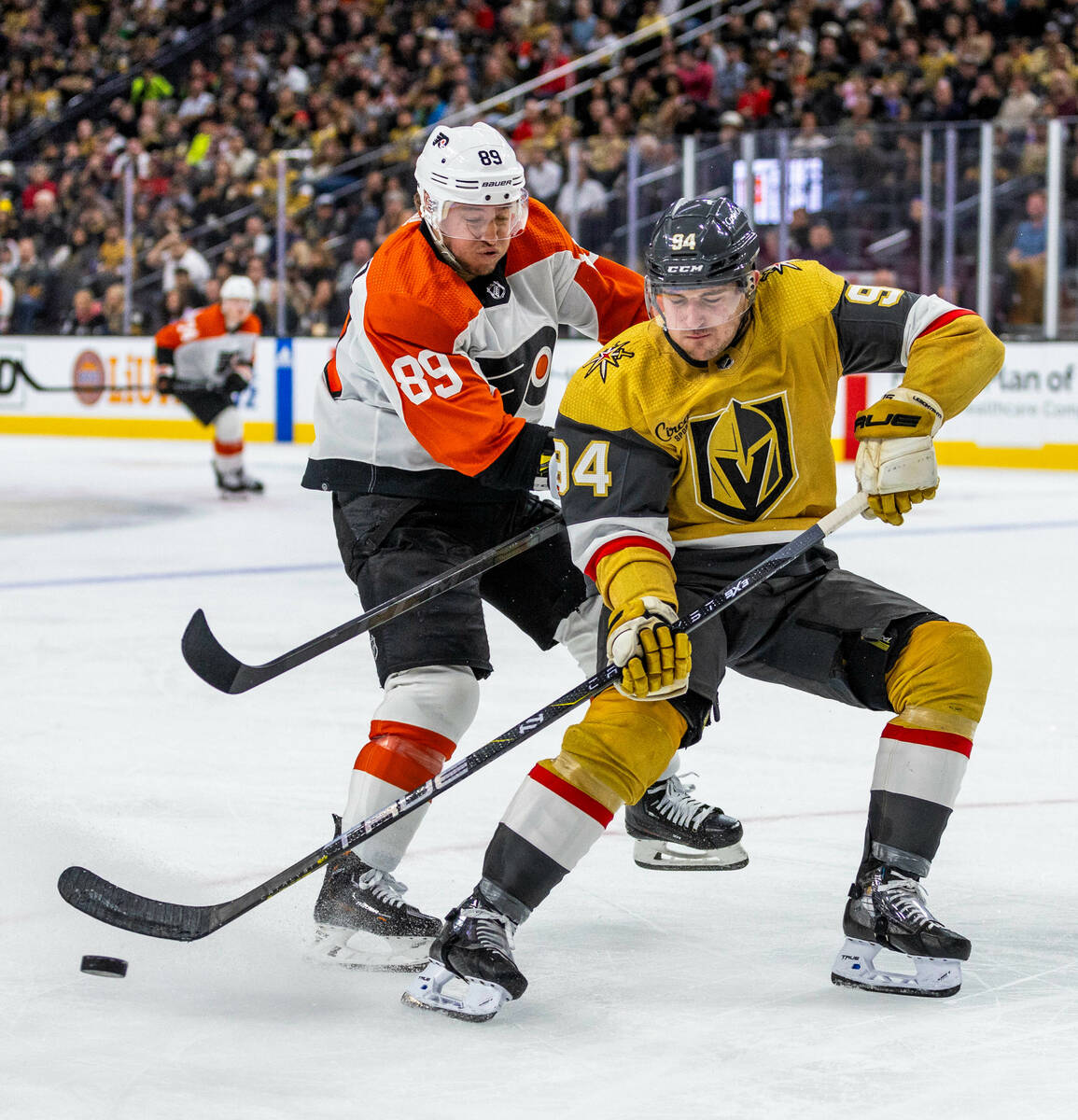 Golden Knights defenseman Brayden Pachal (94) chases down a puck and keeps it from Philadelphia ...
