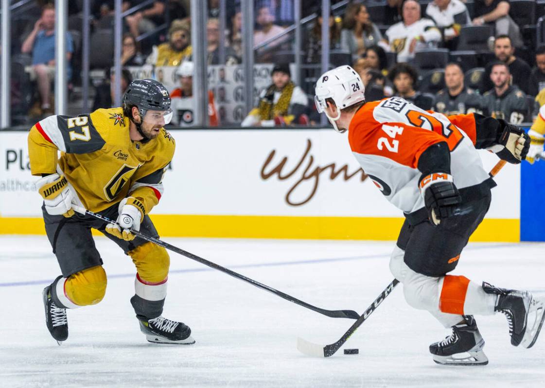 Golden Knights defenseman Shea Theodore (27) looks to score past Philadelphia Flyers defenseman ...