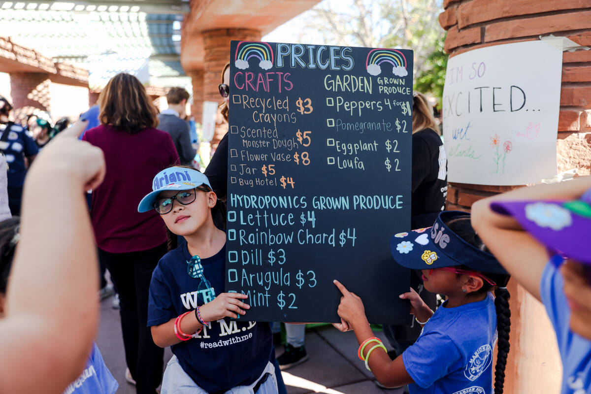 Ariani Peña, 9, left, and Jessie Cruz, 8, right, from Marion Earl Elementary School, hold a si ...