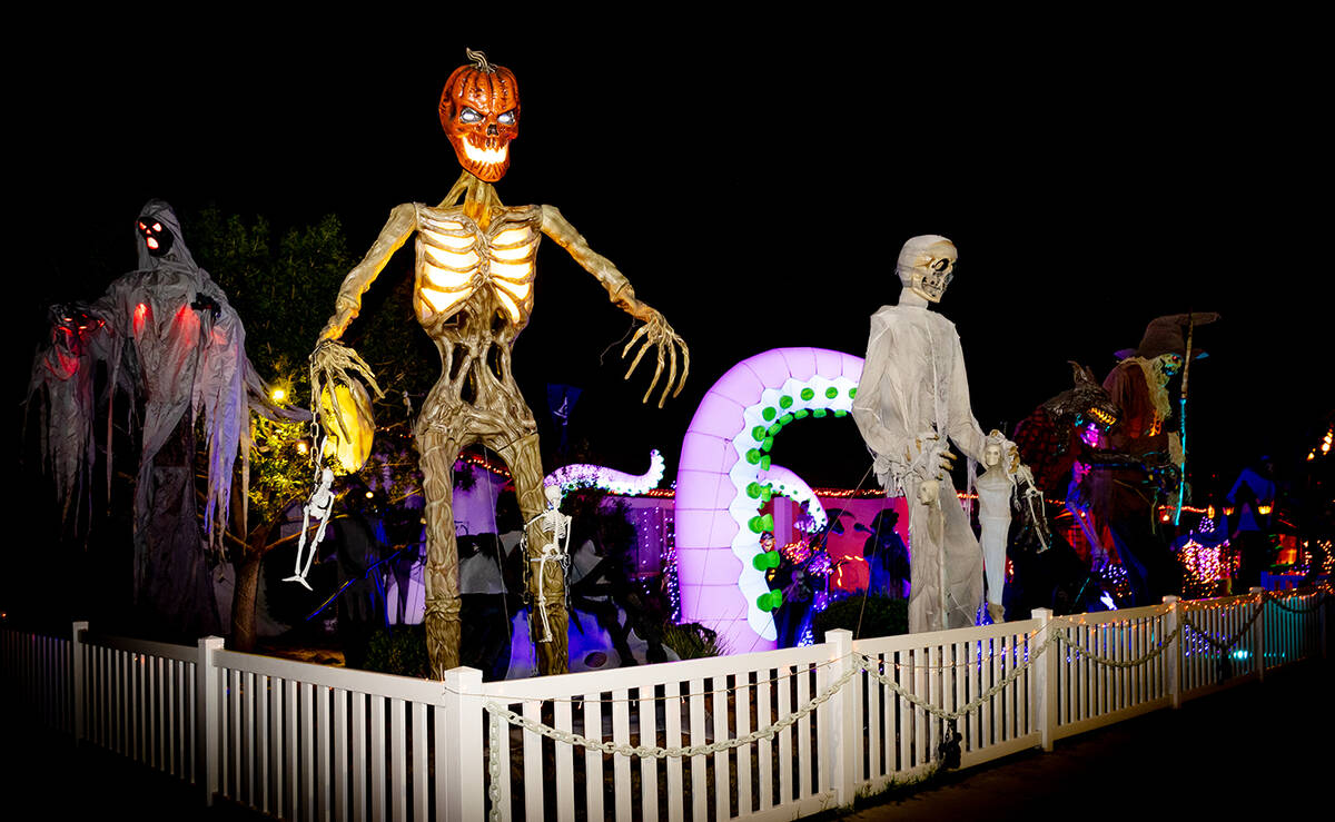 Matching 12-foot pumpkin-headed skeletons flank each side of the yard with realistic LED eyes t ...