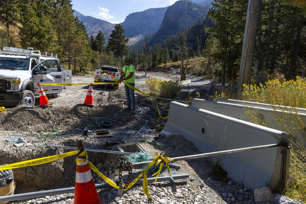 A Las Vegas Valley Water District crew reworks the lines in the Trail Canyon parking lot as rep ...